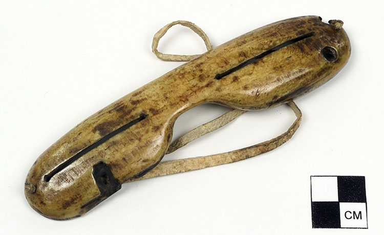 Carved ivory snow goggles with narrow slits to let in light