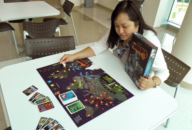 A young woman playing Pandemic