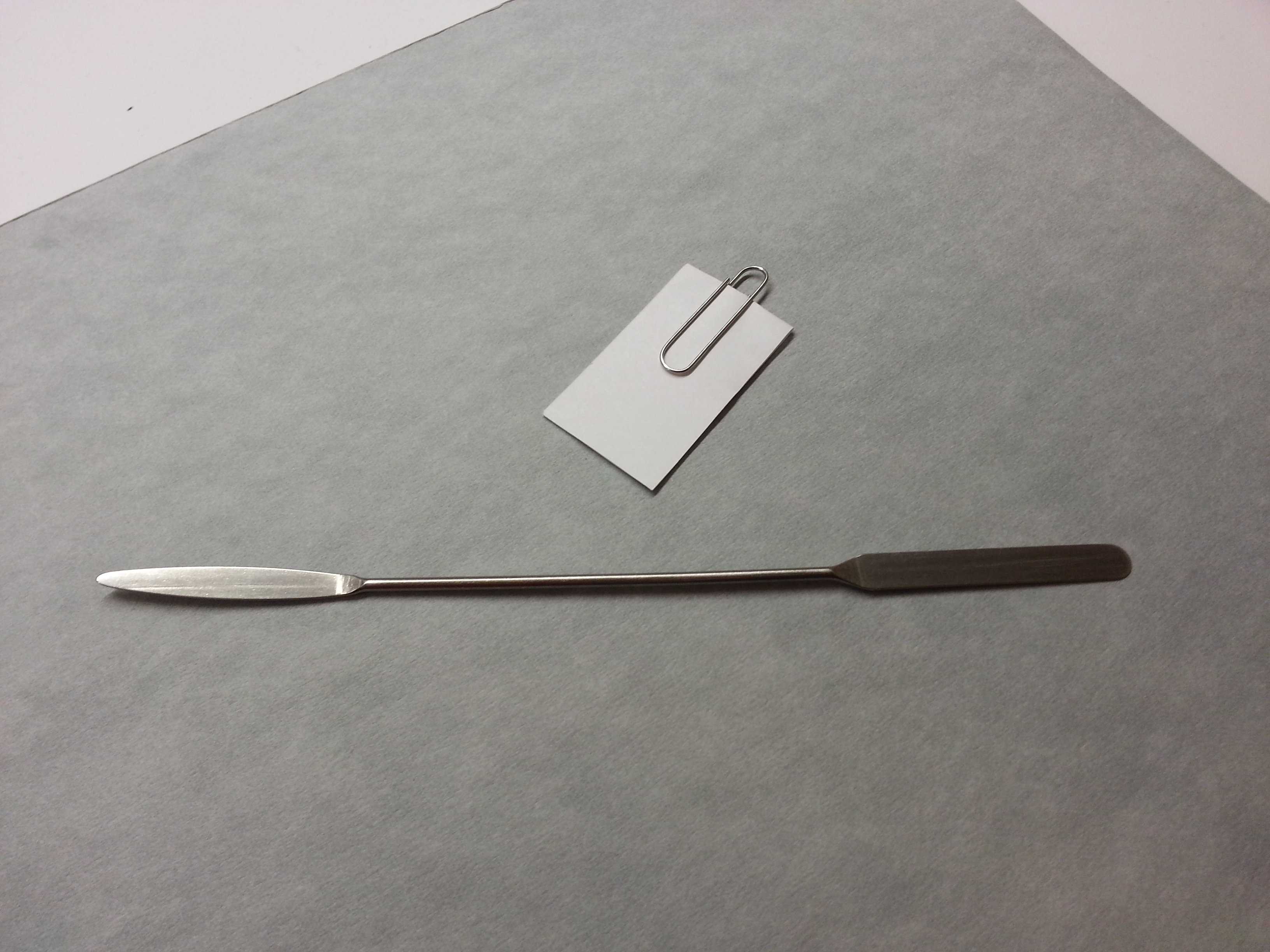 Micro spatula and archival bond paper with stainless steel paperclip.