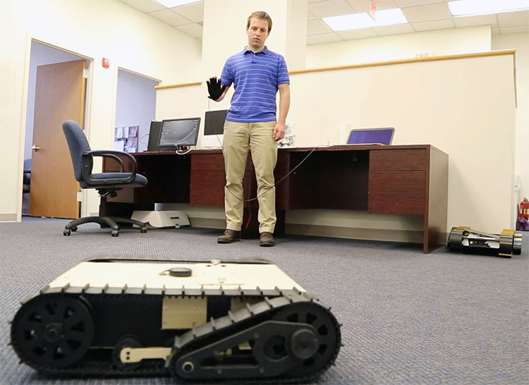 AnthroTronix employee manipulating robot with glove control