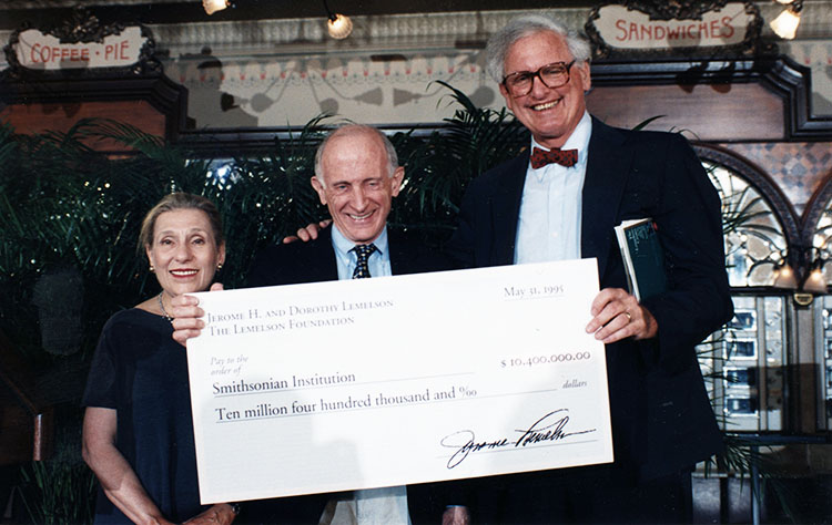 Three people holding an oversized check.