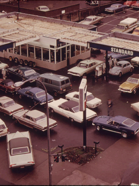 A crowd of cars gathers to wait in line for gas at a gas station during gas rationing of 1973.