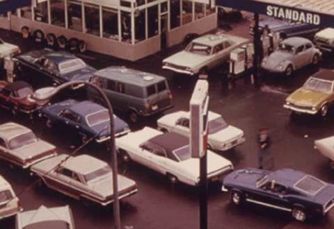 A crowd of cars gathers to wait in line for gas at a gas station