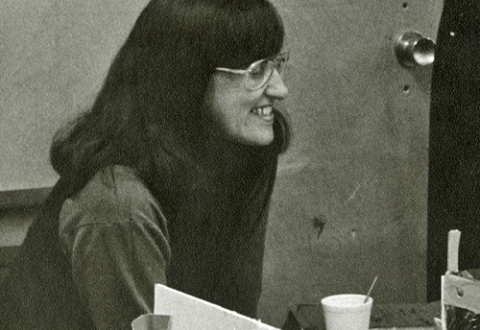 Detail of a photo of Elaine Ostroff, on left, with two other women, looking at a model of a play space. The words Play Room are on the door behind Ostroff.