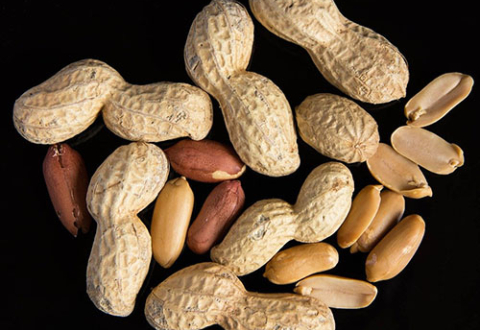 A handful of peanuts against a black background