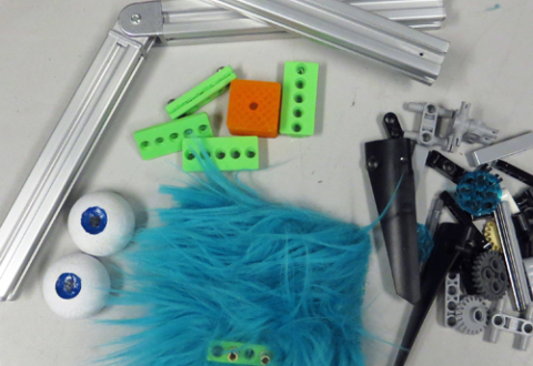 An array of parts from which a creature can be made; includes blue polyester fur, hinged aluminum rods, miscellaneous Lego bits and 3D-printed parts, and small balls made into eyes.