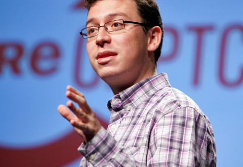 Luis von Ahn stands in front of a large red ReCAPTCHA logo while speaking at the 2009 Pop!Tech conference in Camden, Maine.