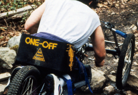 Rear view of a cyclist traveling downhill on Augspurger’s handcycle