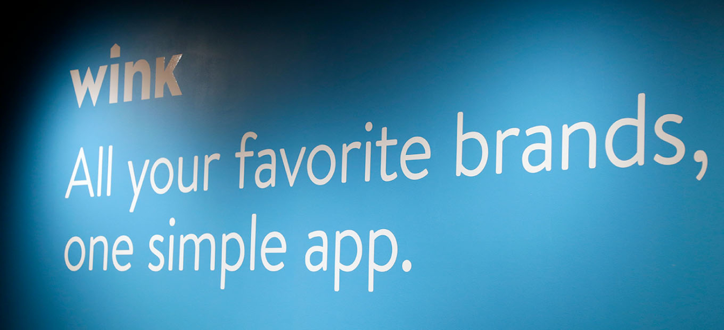 Wink brand logo painted on a wall with the tagline, "All your favorite brands, on one simple app."