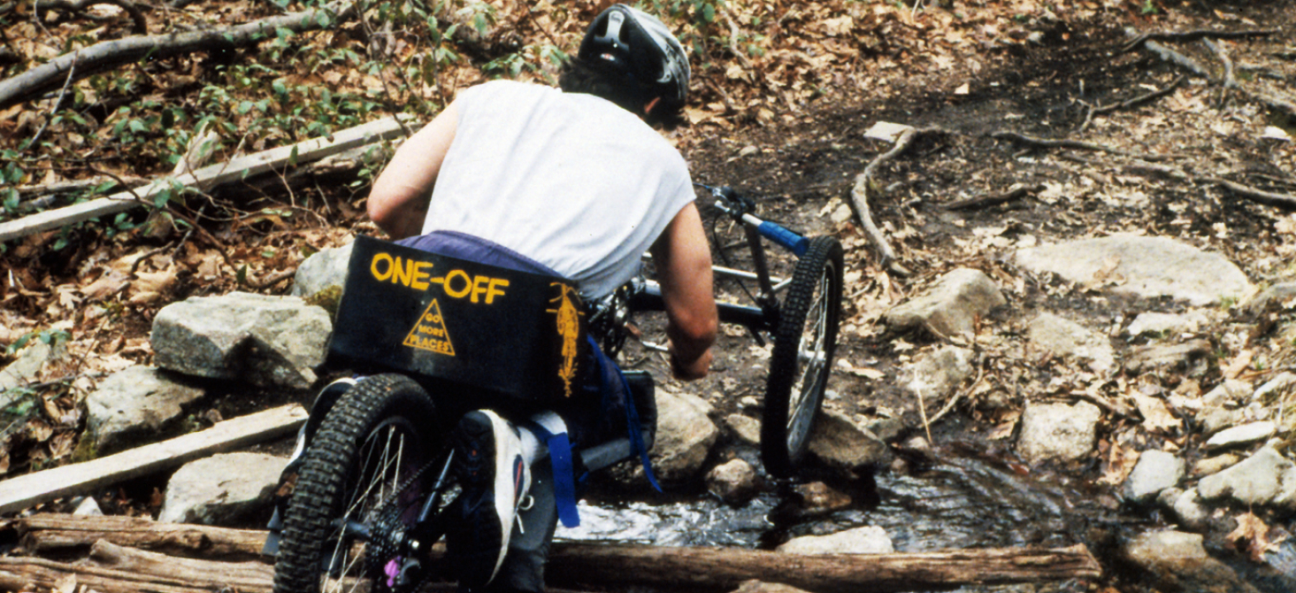 Rear view of a cyclist traveling downhill on Augspurger’s handcycle