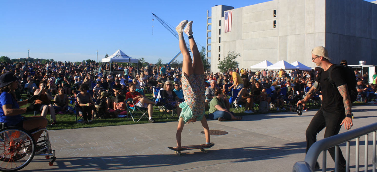 A woman skater standing on her hands on a skateboard