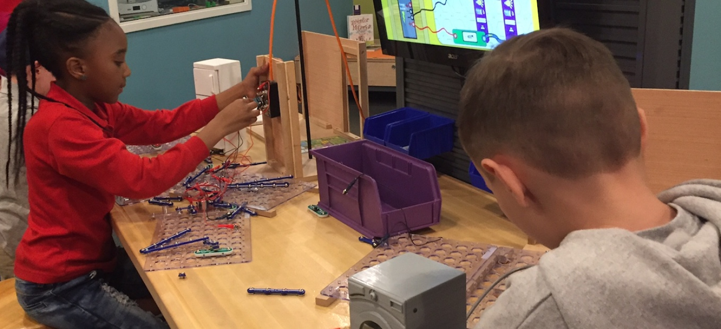 Two young visitors explore the Electrify a Room in Your Home activity in Draper Spark!Lab