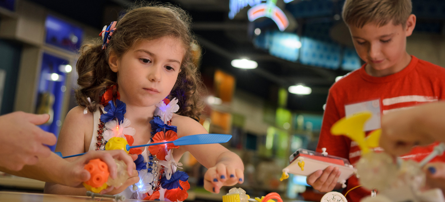 A young girl and boy working on a SparkLab activitiy