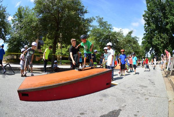 Pros teaching kids how to skateboard at Innoskate's clinic.