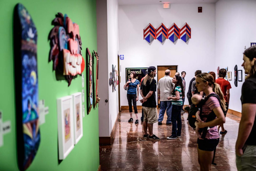 Visitors browse the &quot;All Decked Out&quot; skateboard art exhibit.