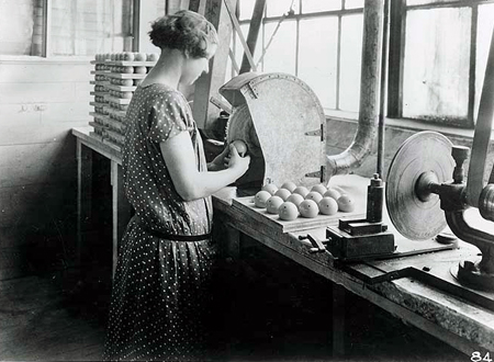 Woman buffing Celluloid billiard ball during manufacturing process