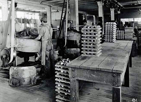 Man grinding Celluloid billiard balls with water and a fine abrasive during manufacturing process