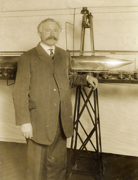 Emile Bachelet standing next to his model prototype for a maglev train