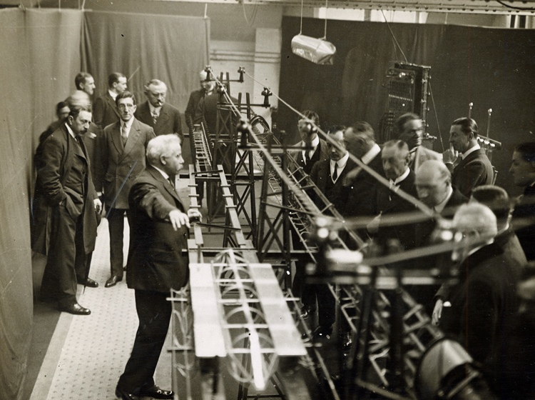 Emile Bachelet demonstrating his maglev train prototype to a group of people in London, 1914