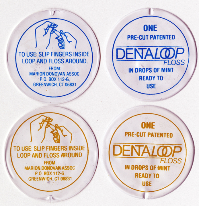 4 foil packets of DentaLoop floss, 2 with blue printing and 2 with orange-brown printing. Each packet reads “One pre-cut patented DentaLoop floss in drops of mint ready to yse” on one side and “To use: slip fingers inside loop and floss around. From Marion Donovan Assoc. P.O. Box 112-G, Greenwich, CT 06831” on the reverse side.