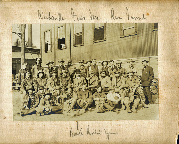 Posed group photo of about 30 tunnel workers