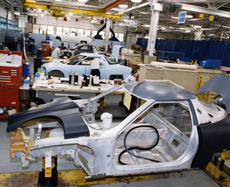 EV1 prototype under assembly, 1994. A partial chassis is in the foreground with a car having its outer body assembled is in the mid-ground.