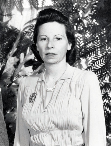 Enid Bissett standing in front of greenery