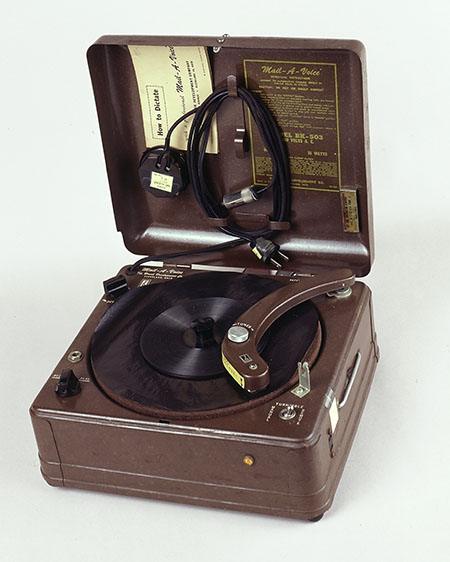 A square machine with a lid. It looks like an old-fashioned record player.