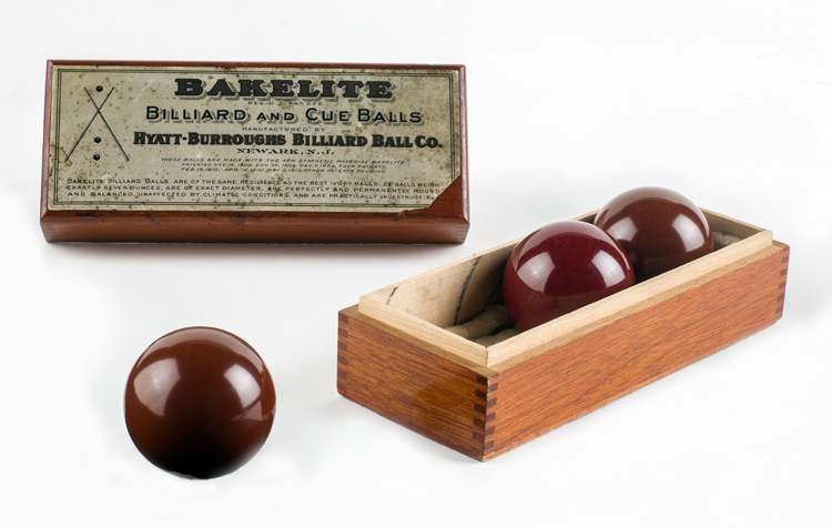 Wooden box holding 3 billiard balls labeled Bakelite