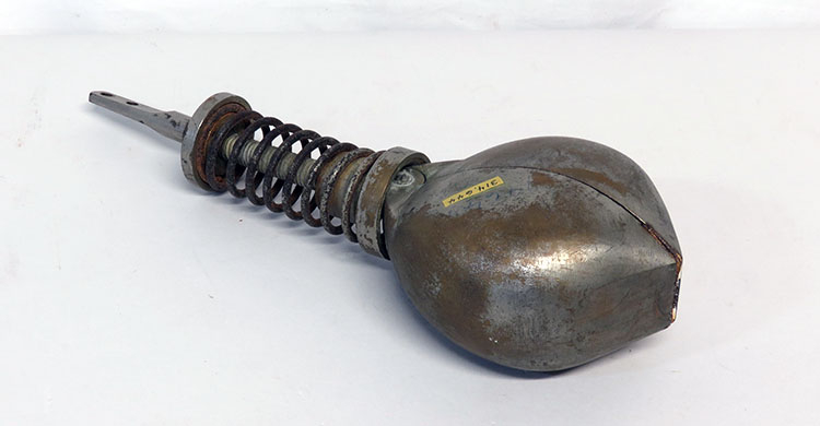 A two-part scoop, shown closed, with a large spring on the handle