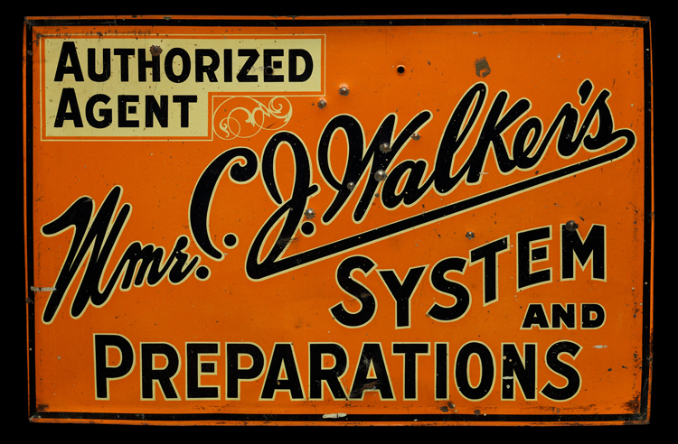 An orange metal sign with black lettering, reading “Authorized Agent (highlighted in yellow). Mme. C. J. Walker’s System and Preparations.” Mme. C. J. Walker’s is written in cursive across the diagonal of the sign, from lower left to upper right. The other words are written in block letters.