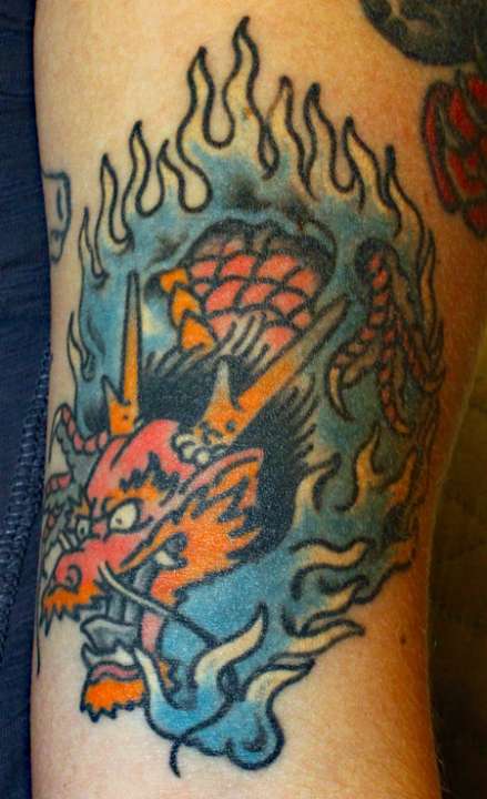 Tattoo of a dragon engulfed in blue flames