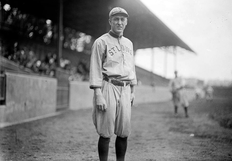 Rickey in his baseball uniform standing on the field sidelines