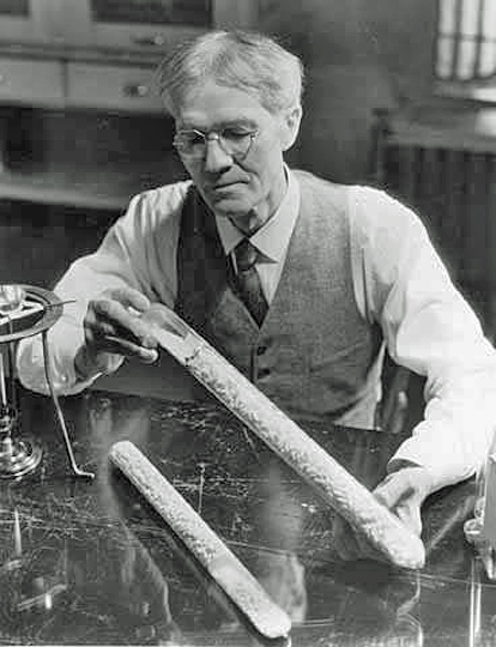 Alexander P. Anderson holding and examining his puffed grain cannon, 1933