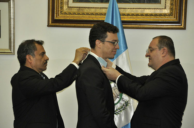 Two men present Luis von Ahn with the Guatemalan government’s highest honor, the Order of the Quetzal, by placing it around his neck.