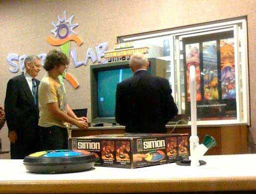 Inventor Ralph Baer plays Odyssey with a museum visitor while his co-inventor Bill Harrison looks on.