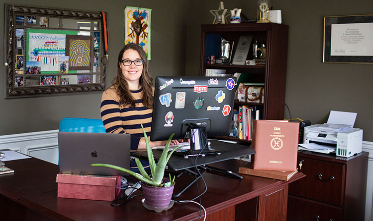 Astigarraga sitting at her desk in front of her computer