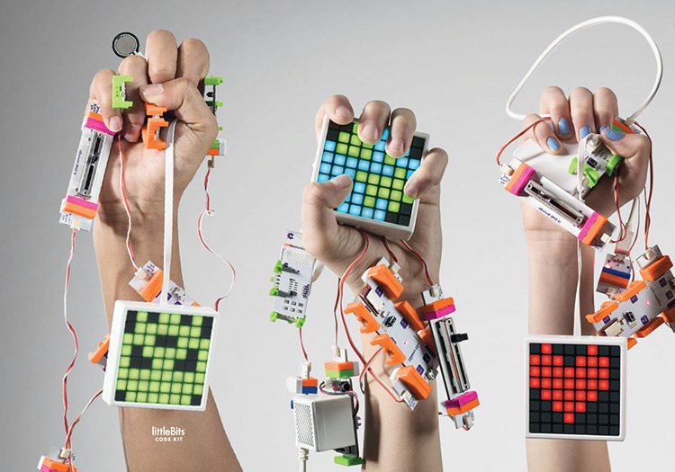 Three hands holding up connected littleBits