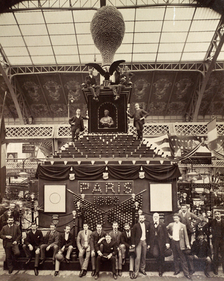 Hammer and his colleagues sitting around the 45-foot tall lamp at the Edison pavilion, 1889 Paris Exposition