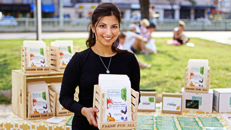 Shukla posing in front of product display table