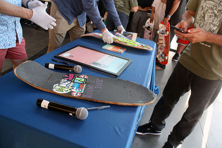 Table with donated objects displayed, including 2 skateboard decks.