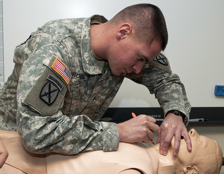 Medic practicing on a medical training manikin