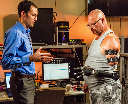 Engineer with soldier testing modular prosthetic arm