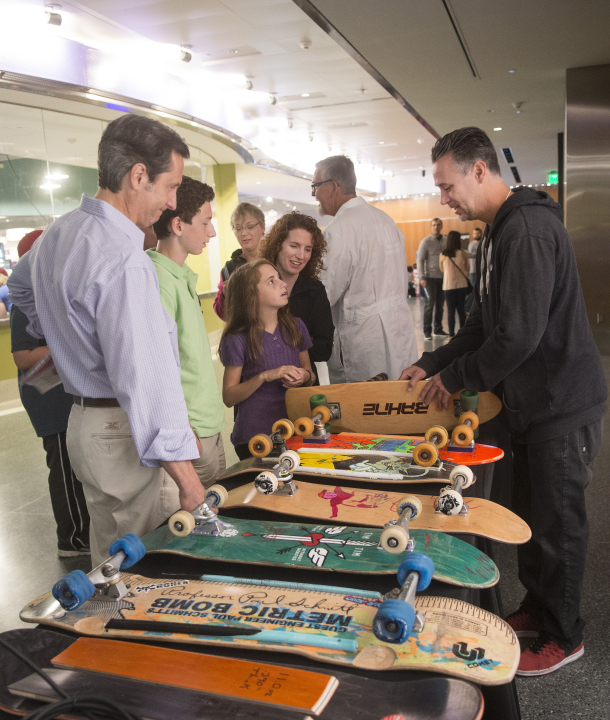 Josh Friedberg demonstrates historic skateboards to visitors to the Innoskate table at the USPTO/Smithsonian Innovation Festival