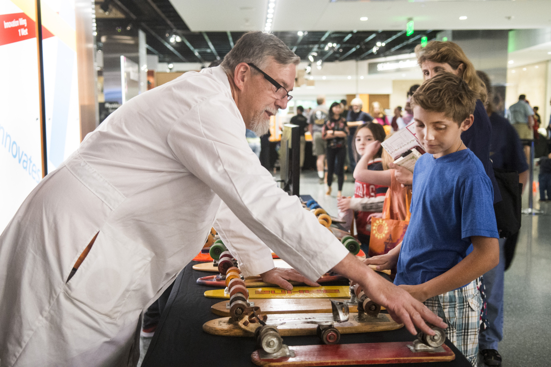 Skateboard inventor Paul Schmitt talks to visitors at the Innoskate table at the USPTO/Smithsonian Innovation Festival