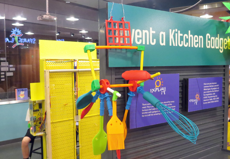 Array of kitchen utensils and other materials hanging from vertical board