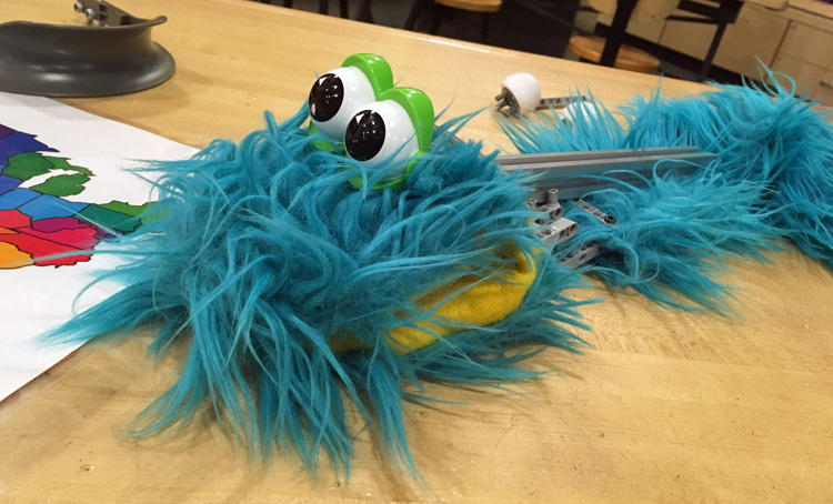 A muppet-like toy made of blue fake fur with big googly eyes