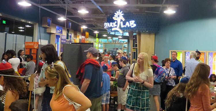 A large crowd of adults and kids in SparkLab