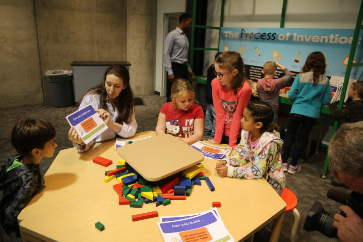 A facilitator works with children on an invention activity at Spark!Lab at Michigan Science Center