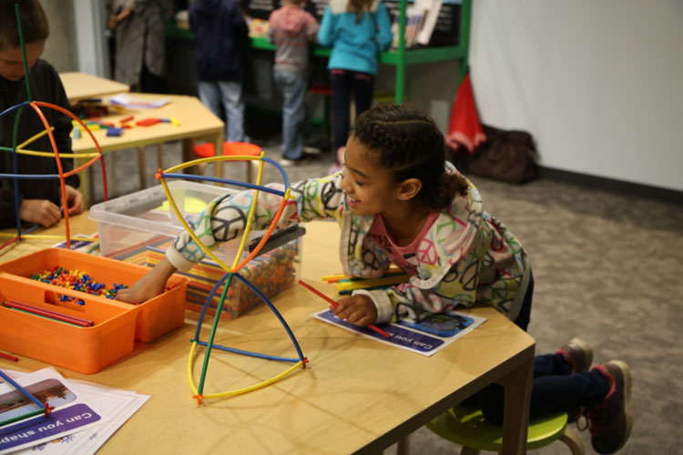 A young girl works on a Spark!Lab activity (Michigan Science Center)